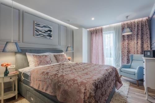 een slaapkamer met een bed en een blauwe stoel bij Apartment Marant Center- free parking in Zadar