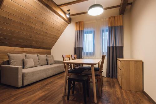a living room with a couch and a table at Madarasi Gyopár Panzió in Izvoare