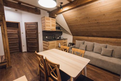 a living room with a table and a couch at Madarasi Gyopár Panzió in Izvoare