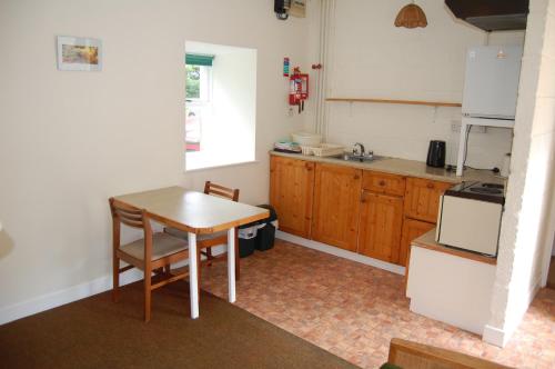 スライゴにあるArdtarmon Barn Cottageの小さなキッチン(木製テーブル、シンク付)