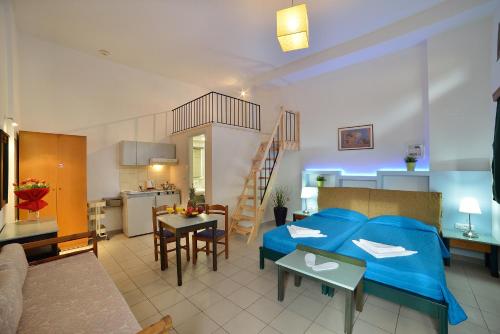 a bedroom with a blue bed and a kitchen at Mythos- Platanias- Hotel -Apts in Plataniás
