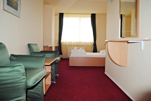 a room with chairs and a bed and a window at CT Tm in Timişoara