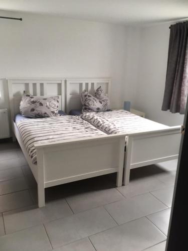a white bed with two pillows on top of it at Ferienwohnung Stricker in Birken-Honigsessen