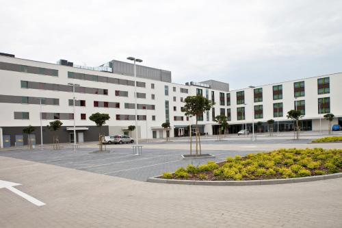 a large white building with a parking lot at Premiere Classe Wroclaw Centrum in Wrocław