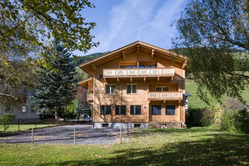a large wooden house with a balcony at Refugium Dolomiten & Chalet in Sillian