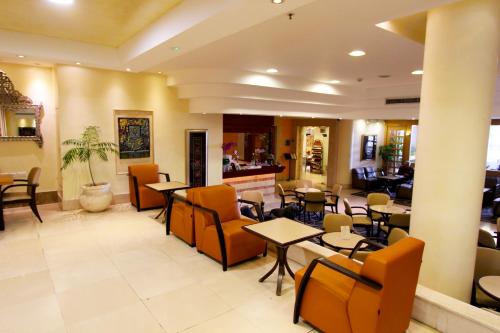 a restaurant with tables and chairs and a bar at Ambassador Hotel in Jerusalem