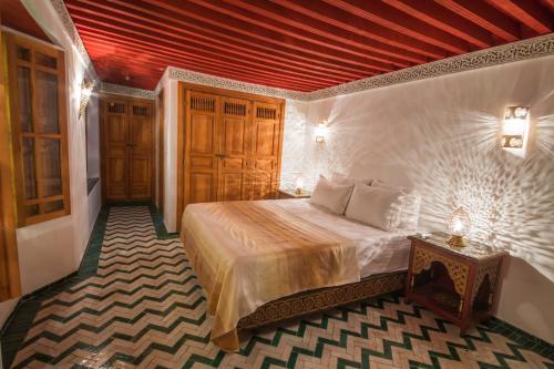 a bedroom with a bed with a red ceiling at Palais Nazha Fes - Luxury Lodging in Fès