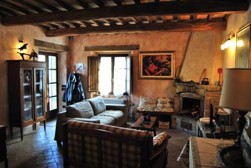 a living room with a couch and a fireplace at Casa Fioranna in Seggiano