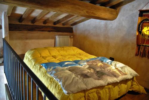 a large bed in a room with a wooden ceiling at Casa Fioranna in Seggiano