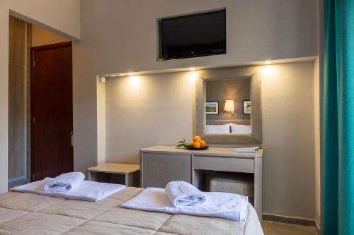 ein Hotelzimmer mit 2 Betten und einem Spiegel in der Unterkunft Apollon Hotel in Antikes Epidauros