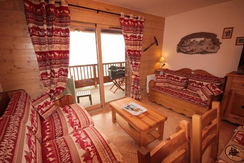 a room with a bed and a table in a room at LES SAISIES - LA PERLE DES ALPES in Les Saisies