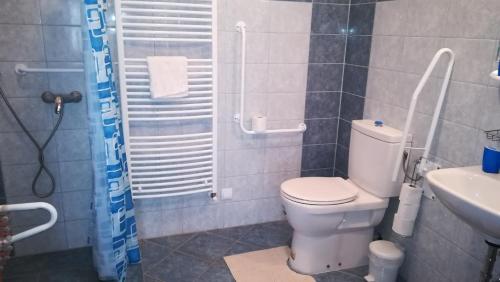 a bathroom with a toilet and a sink at Vár-Liget Vendégház in Kisnána