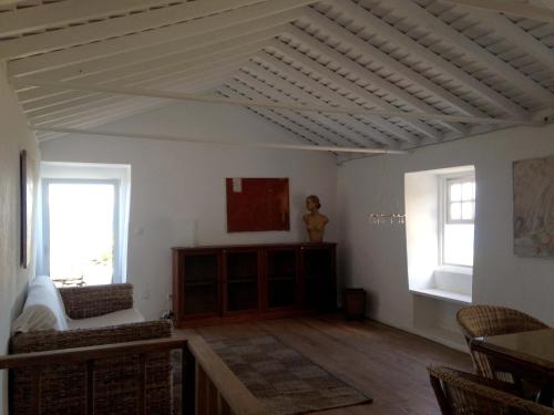 a living room with a white ceiling and two windows at Casa do Alto in Santo António