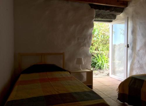 a bedroom with a bed and an open door at Casa do Alto in Santana