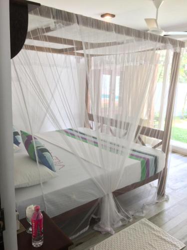 a bedroom with a canopy bed with mosquito nets at Villa Kandy in Kandy