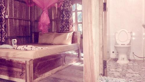 瓜隆岛PSK VIMEAN KOH RONG Guesthouse的一间卧室配有一张床,一间卫生间位于客房内
