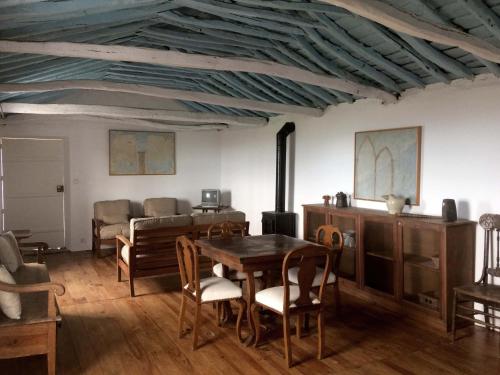a living room with a wooden table and chairs at Casa do Ginjal in Santo Antonio