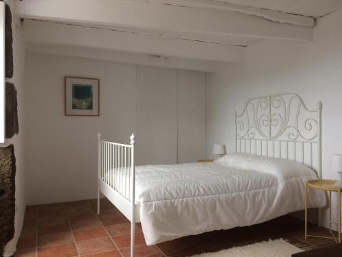 a bedroom with a white bed in a room at Casa do Ginjal in Santo Antonio