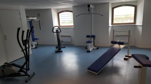 une salle de sport avec des tapis de course et des machines dans une pièce dans l'établissement Aulus-les-Bains, à Aulus-les-Bains