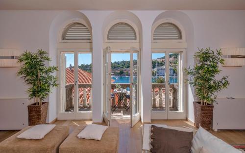 a living room with two couches and large windows at Heraclea House in Hvar