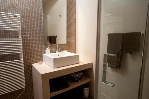 La salle de bains est pourvue d'un lavabo blanc et d'un miroir. dans l'établissement Heraclea House, à Hvar