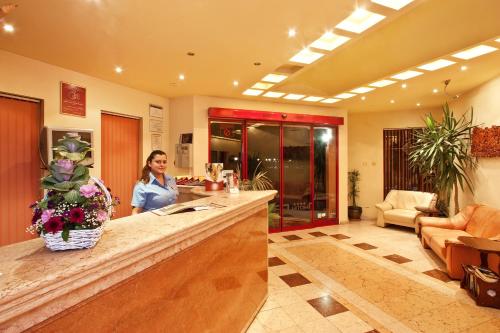 a woman standing at a bar in a room at Saint George Hotel & Medical Spa in Pomorie