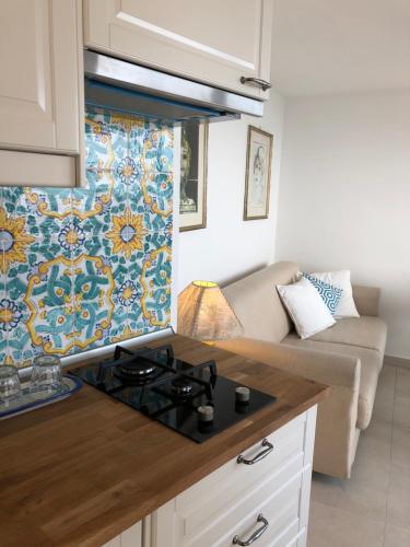 a kitchen with a stove top oven next to a couch at Sciala' in Taormina