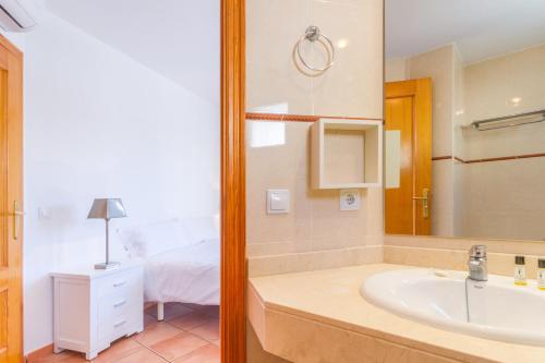 a bathroom with a tub and a sink and a bed at Rooms Cozy House in Ses Salines