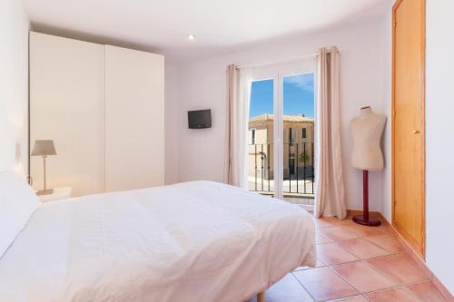 a white bedroom with a large bed and a window at Rooms Cozy House in Ses Salines