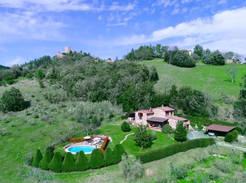 an aerial view of a house on a hill with a pool at Villa esclusiva in Toscana con piscina privata in Montecastelli