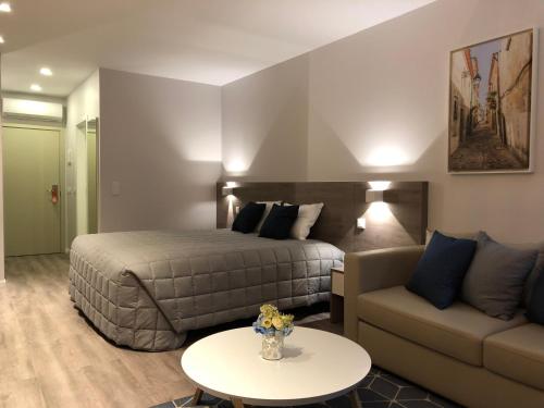 Habitación de hotel con cama y sofá en Hotel do Parque, en Viana do Castelo