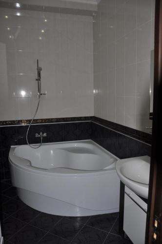 a bath tub in a bathroom with a toilet and a sink at Arcadia Palace Apartments with Sea View in Odesa