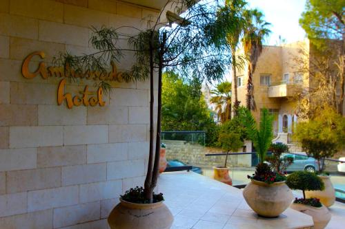 three potted plants are sitting outside of a hotel at Ambassador Hotel in Jerusalem