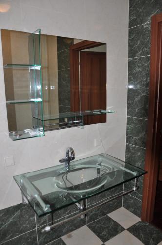 a bathroom with a glass sink and a mirror at Arcadia Palace Apartments with Sea View in Odesa