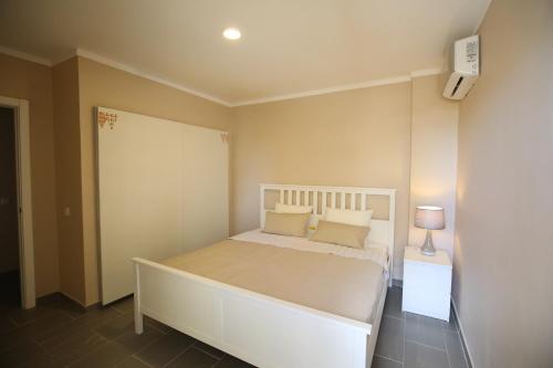 ポルティマンにあるBeco Do Sol Apartment T2のベッドルーム(大きな白いベッド1台、ナイトスタンド付)