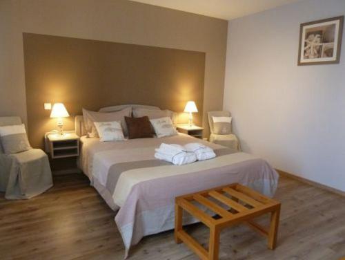 1 dormitorio con 1 cama blanca grande y 2 mesas en Chambres d'Hôtes de la Junchère, en Saint-Hilaire-de-Court