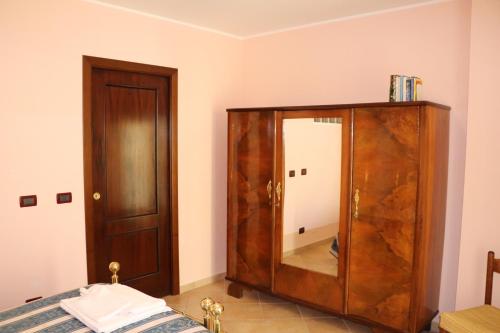 a room with a wooden cabinet with a mirror at B&B La Fonte in Coppito