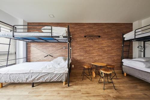 a room with two bunk beds and a table and chairs at Ya Do! KYOTO OKAZAKI in Kyoto