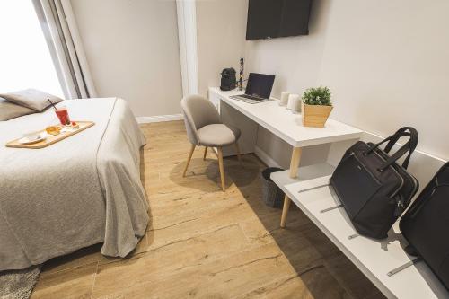a hotel room with a bed, desk, and a chair at Colonna Luxury Suites in Rome