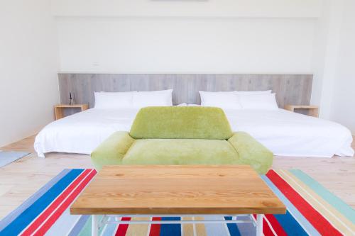 a bedroom with a bed and a green couch at snoozinn in Huxi
