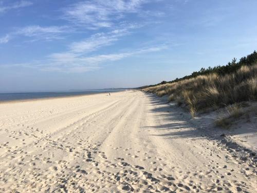 a sandy beach with footprints in the sand at Ferienhaus Duenenwald 1 _LANG in Ostseebad Karlshagen