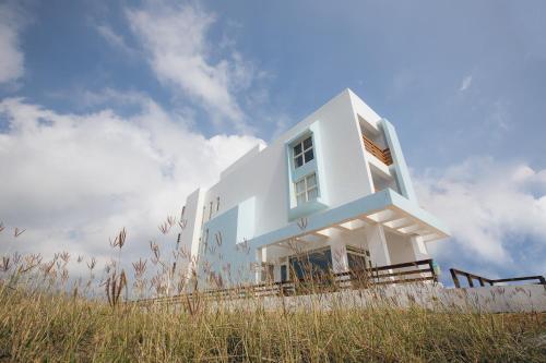 una casa blanca sentada en la cima de una colina en snoozinn, en Huxi