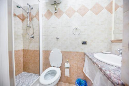 Un baño con inodoro, ducha y lavabo. en Casa Smeraldo, en Cefalú