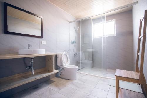 ein Bad mit einem WC, einem Waschbecken und einer Dusche in der Unterkunft snoozinn in Huxi