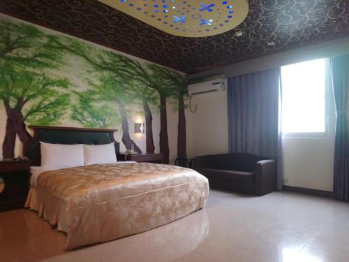 Jiji的住宿－花都汽車旅館 ，卧室配有一张床,墙上挂着一幅树画