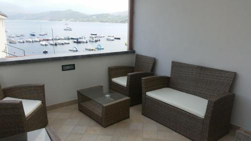 a balcony with chairs and a view of a harbor at O Guarracino Rooms in Palinuro