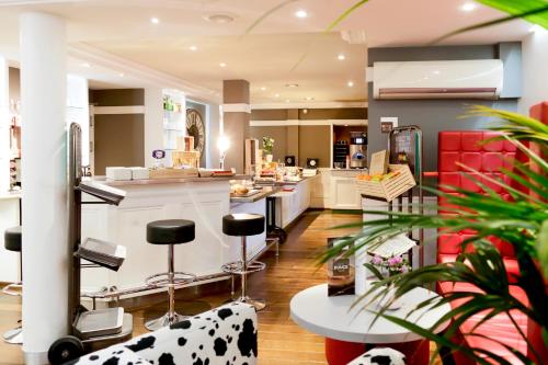 a kitchen with black and white stools and a counter at ibis Dole Sud Choisey in Dole