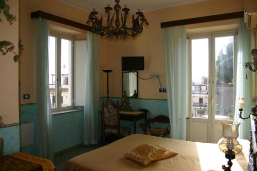 a bedroom with a table and a room with windows at Villa Gaia in Taormina