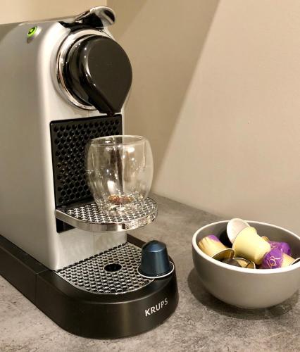 - une cafetière avec un verre de vin et un bol dans l'établissement Appartement Versailles quartier Notre Dame au pied du Chateau avec Parking, à Versailles