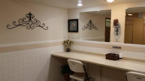 Elk Creek Resort في Piedmont: حمام مع مرآة وحوض مع كرسيين